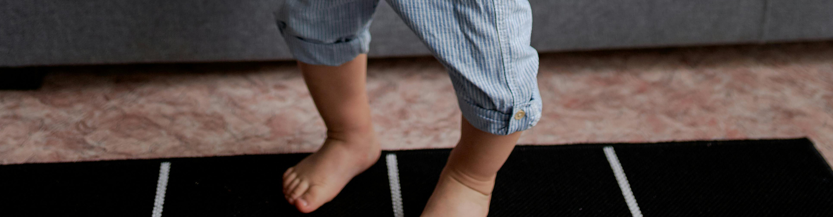 toddler standing on area rug